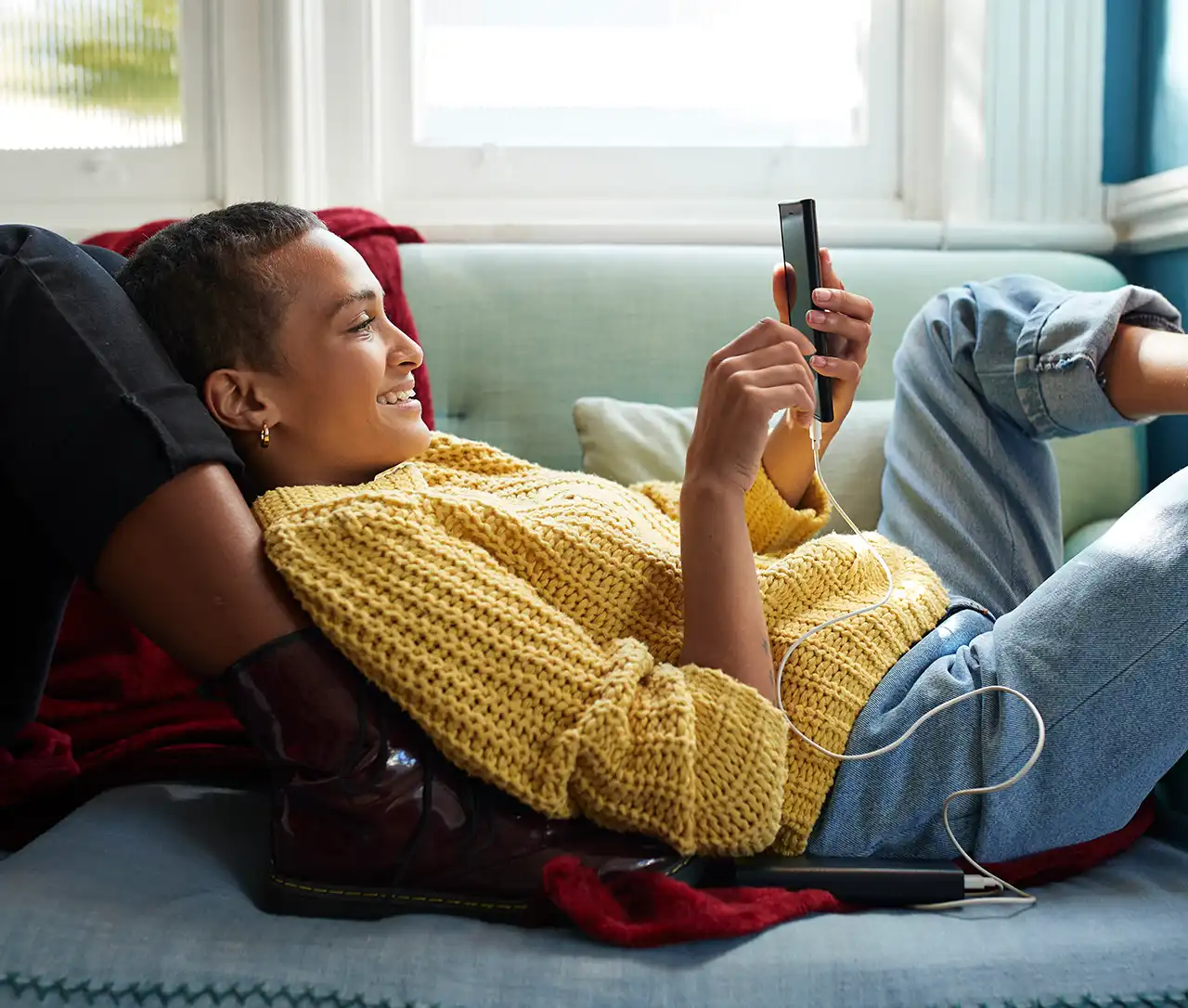 Frau mit Handy auf einem Sofa