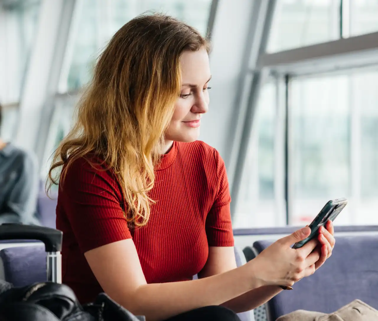 Frau mit Handy am Flughafen