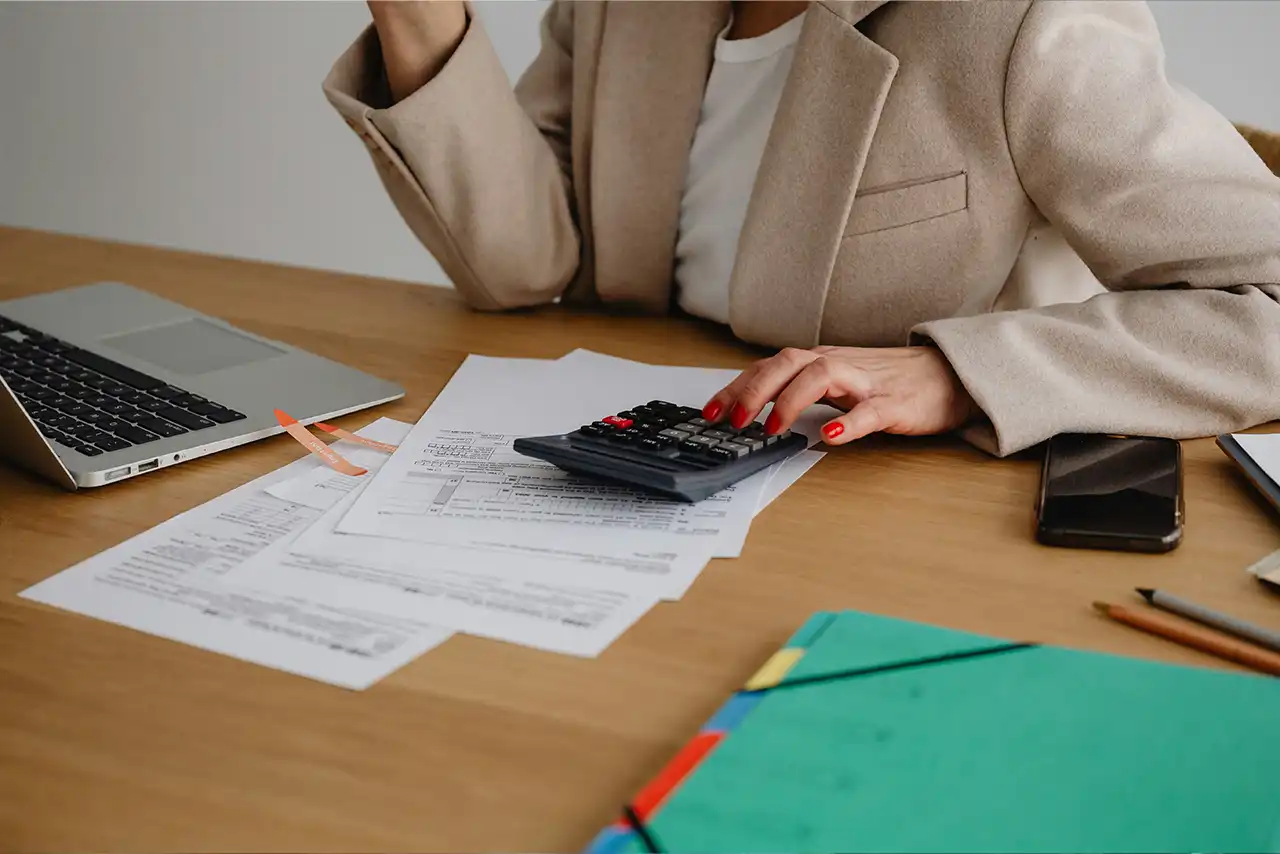 Une femme est assise à table avec une calculatrice.